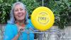 Tita poses with a disc with her PDGA #83 on it